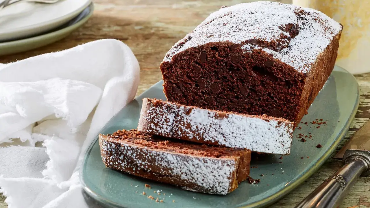 Saftiger Schokoladen-Pfundkuchen, bestäubt mit Puderzucker. Dieses Rezept für Pfundkuchen ist ein Genuss!