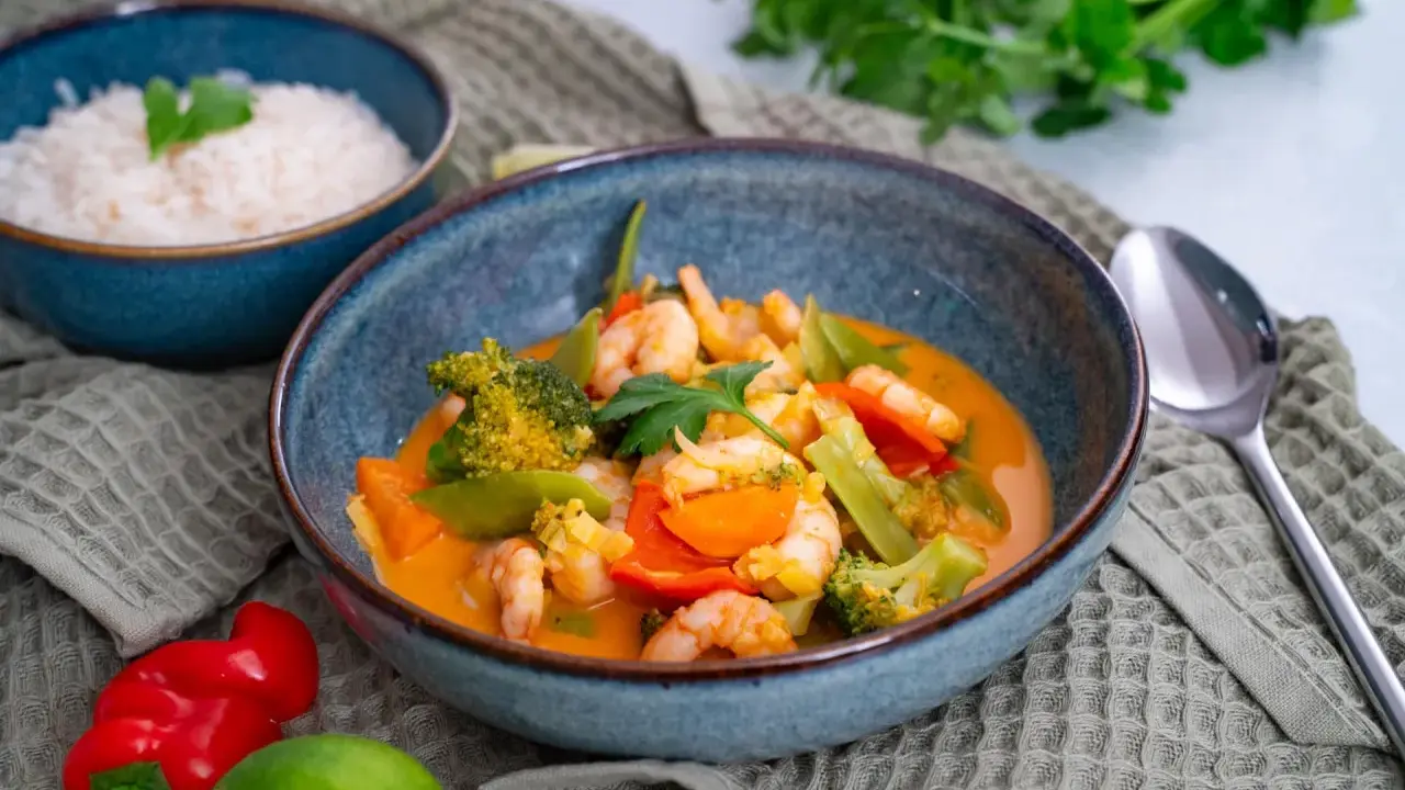 Ein köstliches Thai Curry mit Garnelen, Brokkoli und Karotten in einer cremigen Kokosmilchsauce. Dazu duftender Reis.