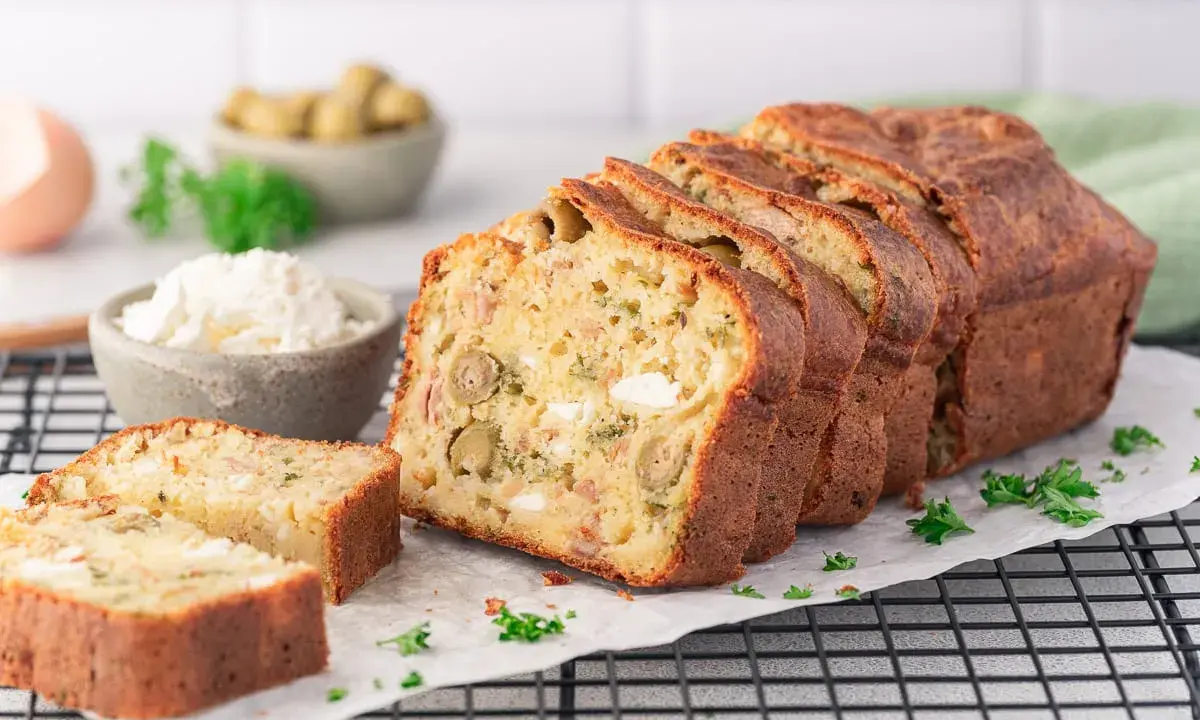 Ein köstlicher, in Scheiben geschnittener Cake Salé mit Oliven und Käse, bereit zum Genießen.
