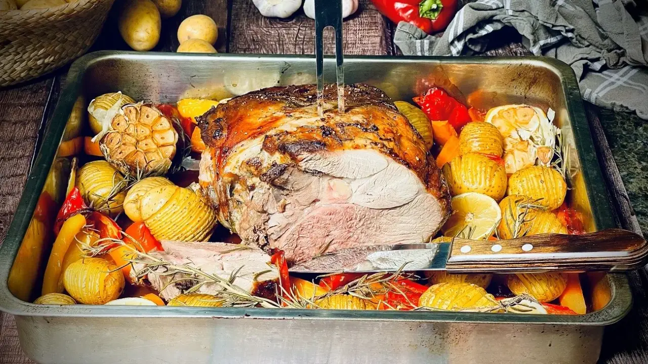 Saftige Lammkeule aus dem Backofen, umgeben von Rosmarinkartoffeln, Knoblauch und Paprika. Ein Festmahl!