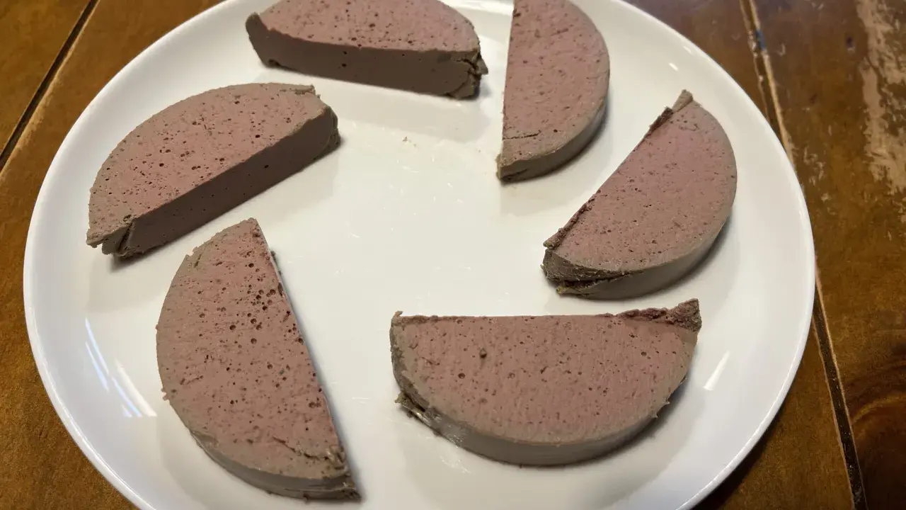 Sechs Scheiben Pastete auf einem weißen Teller, bereit zum Servieren. Ein köstliches pâté rezept, das man probieren muss!