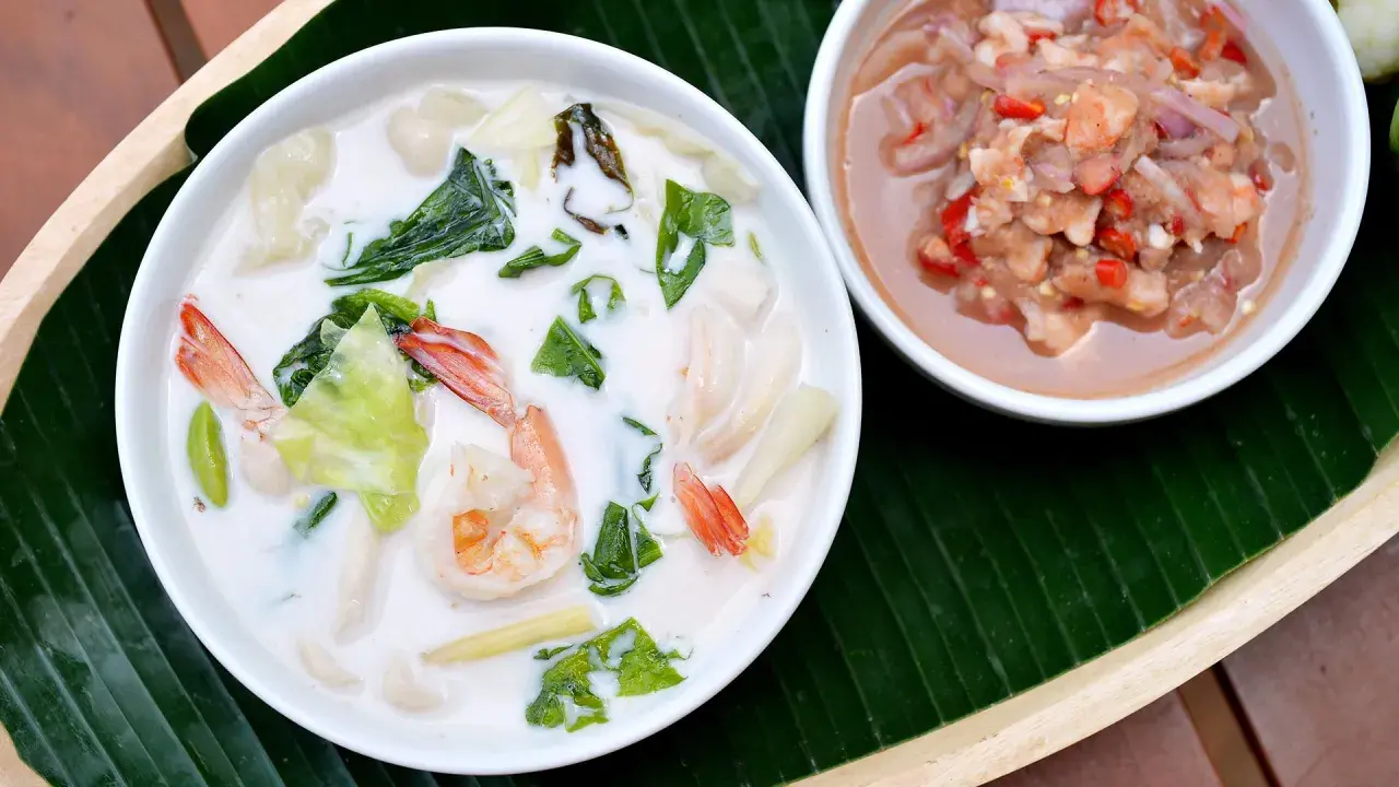 Eine cremige asiatische Suppe mit Garnelen und Gemüse, dane eine Schale mit einer würzigen Garnelenpaste.