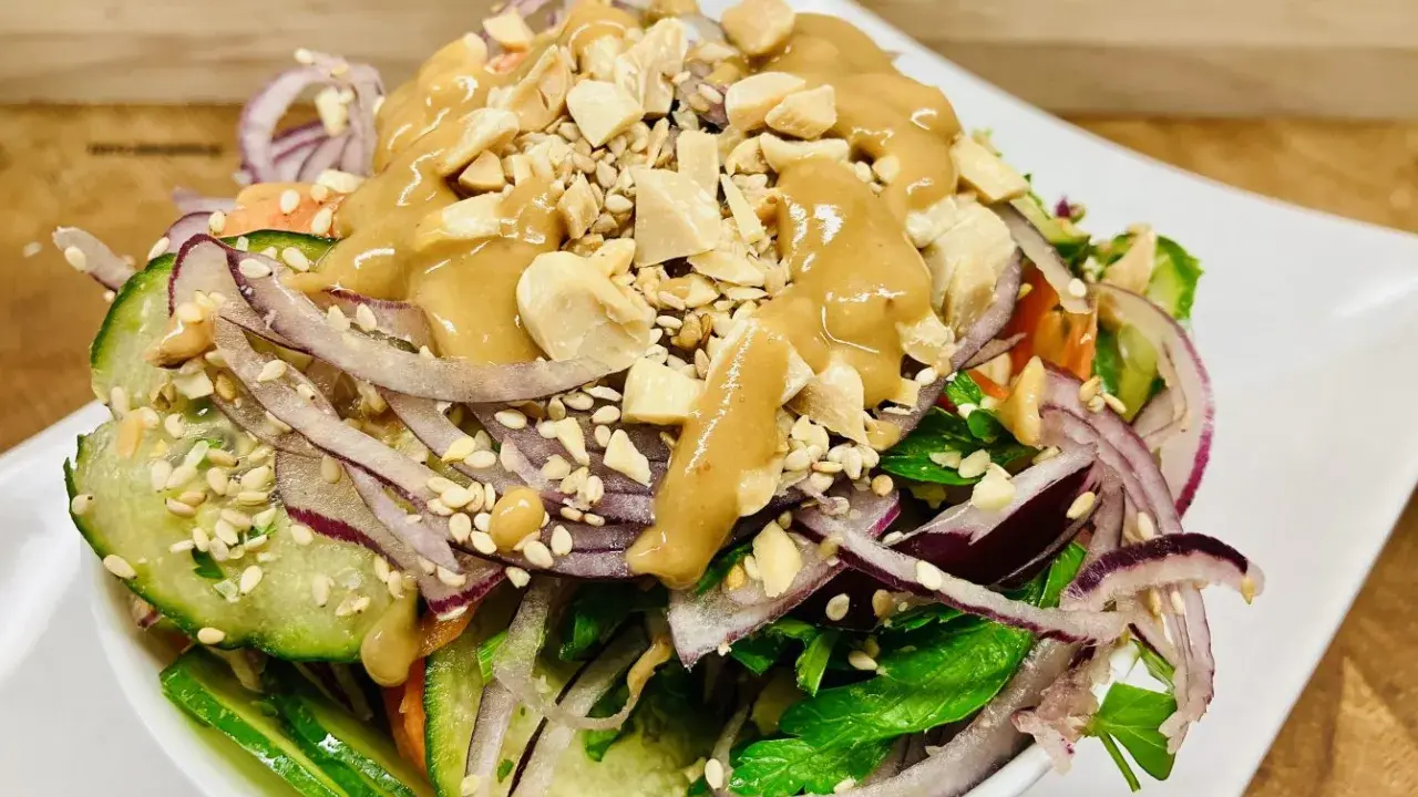 Frischer Salat mit Gurke, roten Zwiebeln, Erdnüssen und einer cremigen Erdnuss-Dressing. Ein köstlicher ingwer salat.