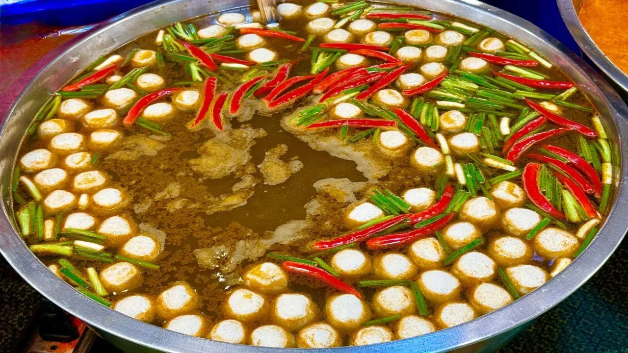 Ein dampfender Topf mit Fleischbällchen, Chilis und Frühlingszwiebeln – ein Einblick in die vielfältigen Esskulturen weltweit.