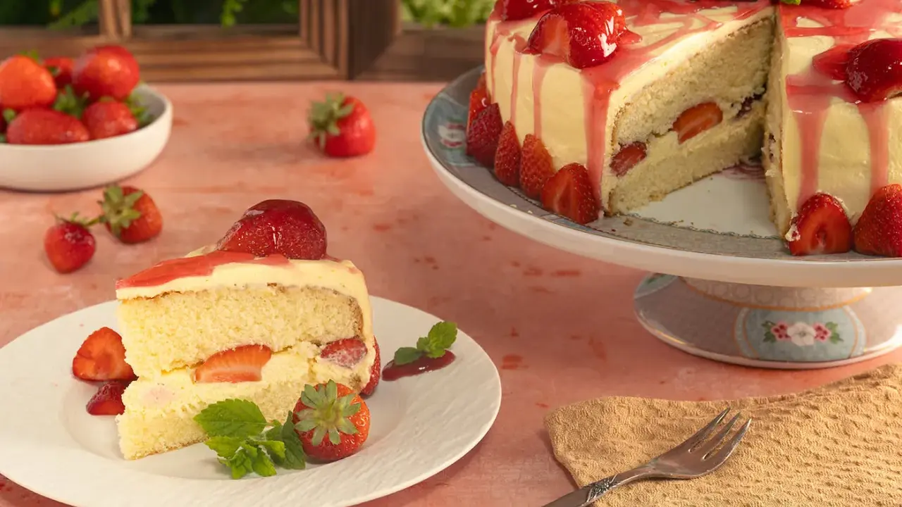 Ein Stück Vanille Erdbeer Torte mit frischen Erdbeeren und Sahne.