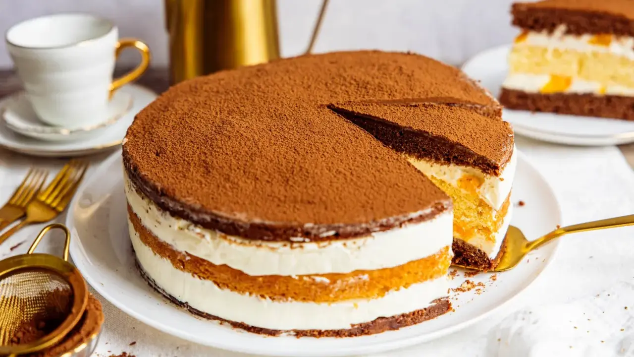 Schokoladenkuchen mit Sahne und Fruchtfüllung, ein köstlicher Kuchen, der 3 Tage durchziehen muss, bestäubt mit Kakao.