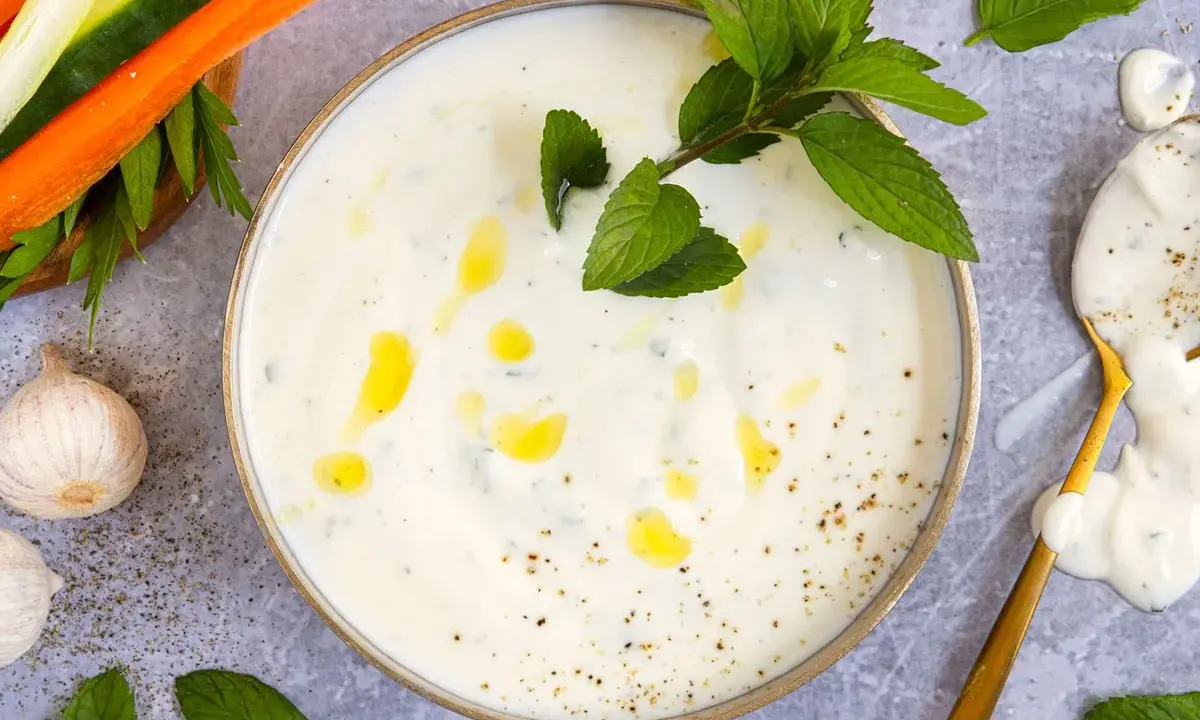 Cremiger Joghurt-Dip mit Minze und Knoblauch, perfekt für ein leichtes minzjoghurt rezept. Dazu Gemüsesticks.