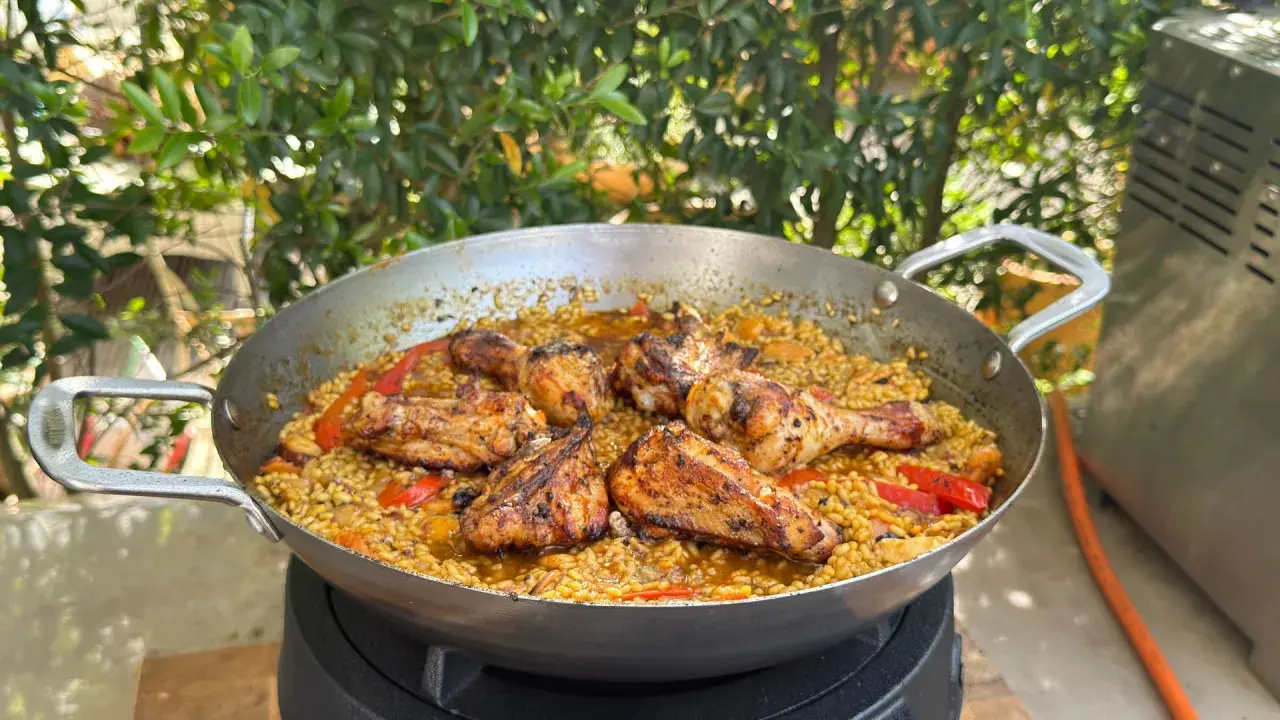 Eine köstliche Paella mit Hähnchenstücken und Paprika, die zeigt, was ist paella: ein herzhaftes Reisgericht.