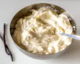 Schüssel mit cremiger, italienischer Vanillecreme, daneben zwei Vanilleschoten.