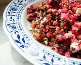 Bunter rote Bete Salat mit Linsen und Feta, garniert mit frischer Petersilie, serviert auf einem Teller mit blauem Blumenmuster.