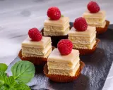 Sechs moderne Petit Fours mit Himbeeren und Minze auf einem Schieferbrett.