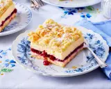 Ein Stück bester Pudding-Kuchen mit Kirschen und Streuseln auf einem blumengemusterten Teller.