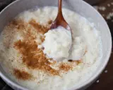 Cremiger Milchreis mit Zimt, der auf einem Holzlöffel serviert wird. Das Waschen des Milchreises ist ein wichtiger Schritt für die perfekte Konsistenz.