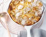 Ein goldbrauner Aprikosen Clafoutis, bestäubt mit Puderzucker und Mandelsplittern, wartet auf seine Verkostung.
