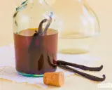 Vanilleextrakt in einer Flasche mit Vanilleschoten daneben. Eine tolle vanilleschote alternative für süße Kreationen.