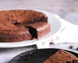 Ein Stück vom originalen Tarte au Chocolat Rezept, saftig und schokoladig, auf einem schwarzen Teller.