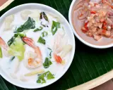 Eine cremige asiatische Suppe mit Garnelen und Gemüse, dane eine Schale mit einer würzigen Garnelenpaste.