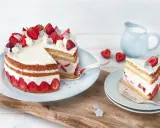 Eine köstliche Erdbeer Basilikum Torte mit frischen Erdbeeren und Sahne, ein Stück davon auf einem Teller.