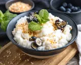 Cremiger Milchreis mit Wasser gekocht, garniert mit Blaubeeren, Minze und gerösteten Kokosflocken. Ein Genuss, der an Kindheit erinnert.