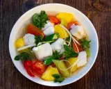 Ein Schüssel Canh Chua mit Fischstücken, Ananas, Tomaten, Okra und Kräutern.