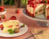 Ein Stück Vanille Erdbeer Torte mit frischen Erdbeeren und Sahne.