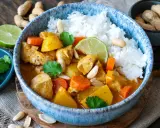 Ein köstlicher Massaman Curry mit Hühnchen, Kartoffeln, Karotten und Erdnüssen, serviert mit Reis. Der Massaman Curry Geschmack ist intensiv und aromatisch.