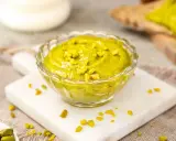 Selbstgemachtes Pistazienmus in einer Glasschale, garniert mit gehackten Pistazien. Perfekt zum Brot oder als Dip.
