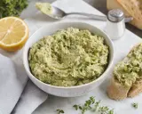 Ein cremiger Zucchini-Aufstrich mit Kräutern und Zitrone, serviert auf Brot.