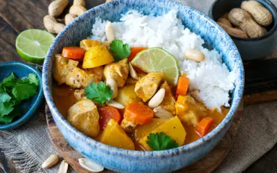 Ein köstlicher Massaman Curry mit Hühnchen, Kartoffeln, Karotten und Erdnüssen, serviert mit Reis. Der Massaman Curry Geschmack ist intensiv und aromatisch.
