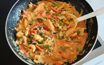 Ein köstliches veganes Curry mit viel Gemüse wie Karotten, Erbsen und Bambussprossen wird in einer Pfanne zubereitet.