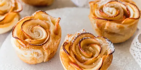 Goldbraune Apfelrosen, perfekt zum Vortag backen, mit Puderzucker bestäubt.