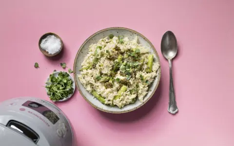 Reis mit Pesto und Spargel, garniert mit Kresse. Daneben Salz, Sprossen und ein Löffel.