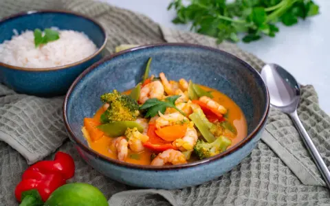 Ein köstliches Thai Curry mit Garnelen, Brokkoli und Karotten in einer cremigen Kokosmilchsauce. Dazu duftender Reis.