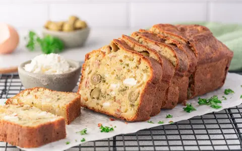 Ein köstlicher, in Scheiben geschnittener Cake Salé mit Oliven und Käse, bereit zum Genießen.