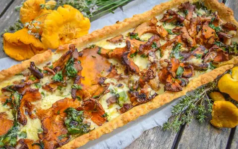 Herzhafte Pfifferling Quiche mit frischen Kräutern und goldgelben Pilzen, ein Genuss für jeden Gaumen.