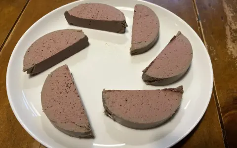 Sechs Scheiben Pastete auf einem weißen Teller, bereit zum Servieren. Ein köstliches pâté rezept, das man probieren muss!