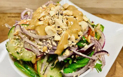 Frischer Salat mit Gurke, roten Zwiebeln, Erdnüssen und einer cremigen Erdnuss-Dressing. Ein köstlicher ingwer salat.