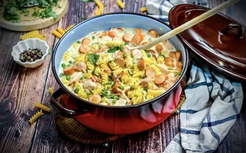 Herzhafte Nudelpfanne mit Würstchen, Erbsen und Hähnchen in cremiger Soße – tolle Suppen Ideen für kalte Tage.