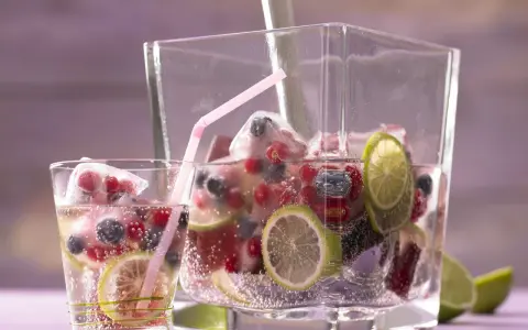 Erfrischendes Getränk mit Beeren, Limetten und Eiswürfeln. Perfekt für sommerliche Limetten Rezepte.