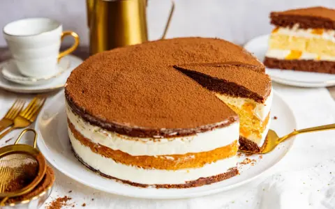 Schokoladenkuchen mit Sahne und Fruchtfüllung, ein köstlicher Kuchen, der 3 Tage durchziehen muss, bestäubt mit Kakao.