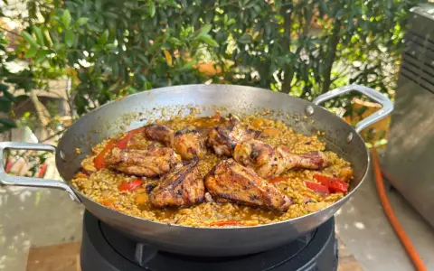 Eine köstliche Paella mit Hähnchenstücken und Paprika, die zeigt, was ist paella: ein herzhaftes Reisgericht.