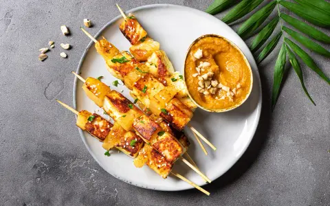 Gegrillte Tofuspieße mit Erdnusssauce, ein köstliches Gericht, das von asiatischen Rezepten inspiriert ist.