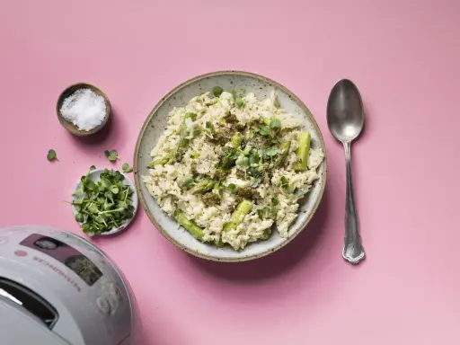 Reis mit Pesto und Spargel, garniert mit Kresse. Daneben Salz, Sprossen und ein Löffel.