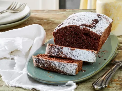 Saftiger Schokoladen-Pfundkuchen, bestäubt mit Puderzucker. Dieses Rezept für Pfundkuchen ist ein Genuss!