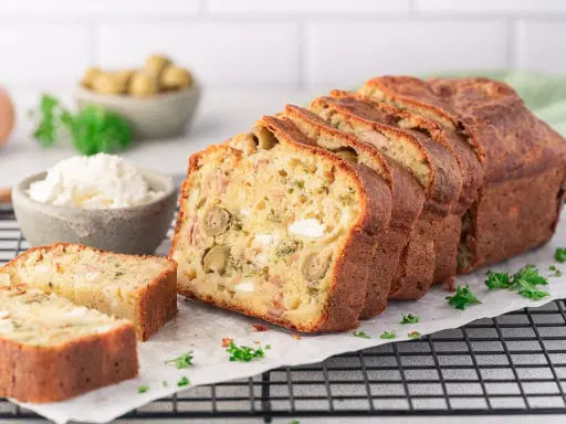 Ein köstlicher, in Scheiben geschnittener Cake Salé mit Oliven und Käse, bereit zum Genießen.