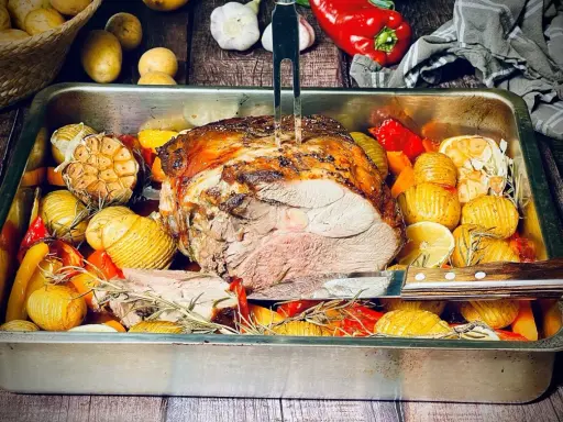 Saftige Lammkeule aus dem Backofen, umgeben von Rosmarinkartoffeln, Knoblauch und Paprika. Ein Festmahl!