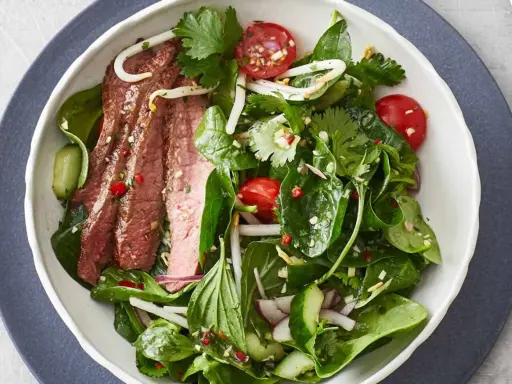 Ein frischer Thai-Rindfleischsalat mit zarten Rindfleischstreifen, knackigem Gemüse und Kräutern.