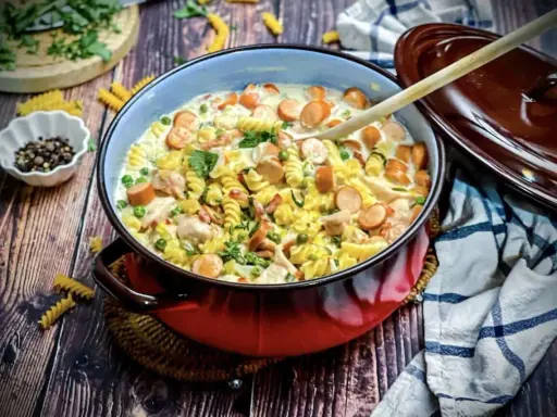 Herzhafte Nudelpfanne mit Würstchen, Erbsen und Hähnchen in cremiger Soße – tolle Suppen Ideen für kalte Tage.