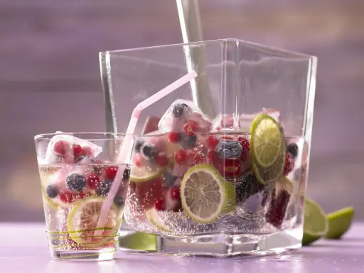 Erfrischendes Getränk mit Beeren, Limetten und Eiswürfeln. Perfekt für sommerliche Limetten Rezepte.