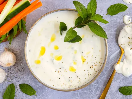 Cremiger Joghurt-Dip mit Minze und Knoblauch, perfekt für ein leichtes minzjoghurt rezept. Dazu Gemüsesticks.